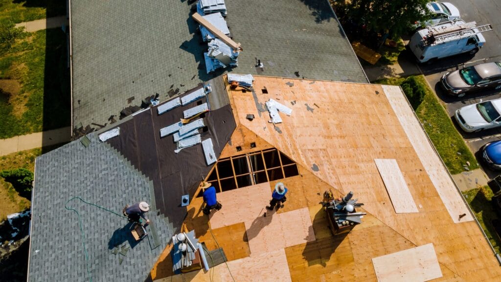 Aerial view of roof replacement with workers installing new materials.