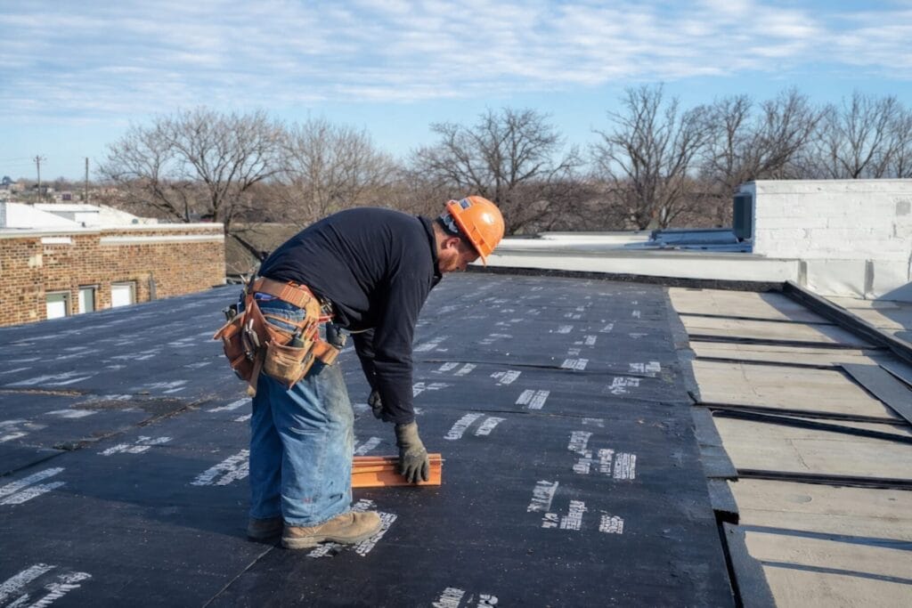 Commercial roofing contractor installing a flat roof membrane.